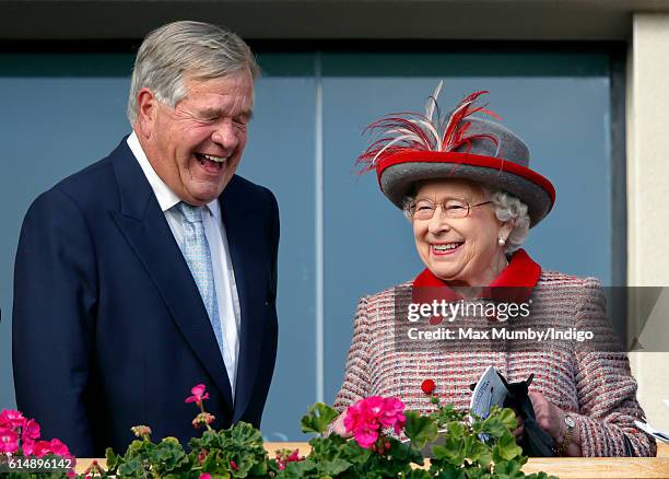 Queen Elizabeth II shares a joke with race horse trainer Sir Michael Stoute as she attends the QIPCO British Champions Day racing meet at Ascot...