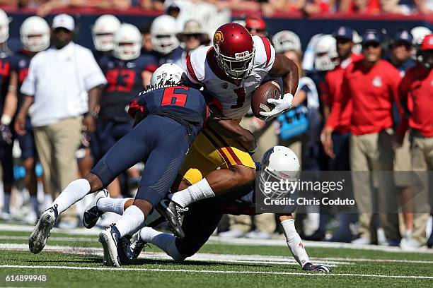 Wide receiver Darreus Rogers of the USC Trojans is hit by safety Demetrius Flannigan-Fowles and cornerback Jace Whittaker of the Arizona Wildcats...