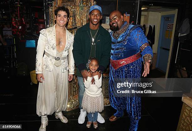 Adam Jacobs as "Aladdin", NY Giants Victor Cruz, daughter Kennedy Cruz and James Monroe Iglehart as "The Genie" pose backstage at "Disney's Aladdin"...