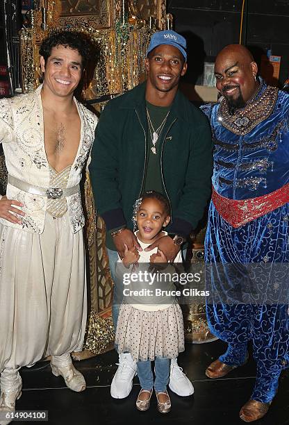 Adam Jacobs as "Aladdin", NY Giants Victor Cruz, daughter Kennedy Cruz and James Monroe Iglehart as "The Genie" pose backstage at "Disney's Aladdin"...