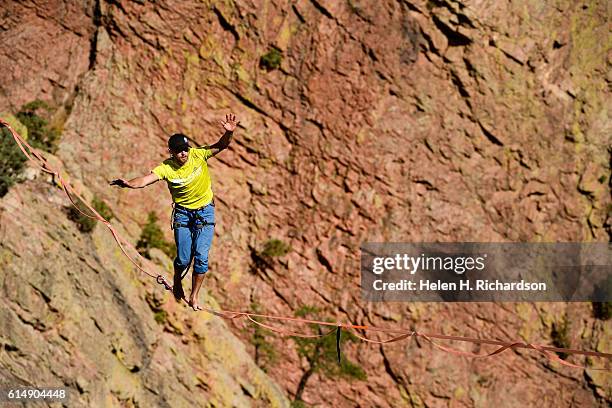 Taylor VanAllen makes the FA, or First Across, on a high-line from the Wind Tower rock formation to the Bastille rock formation 450 feet off the...