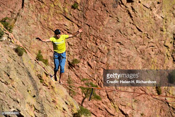 Taylor VanAllen makes the FA, or First Across, on a high-line from the Wind Tower rock formation to the Bastille rock formation 450 feet off the...