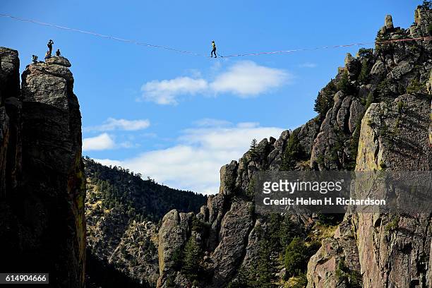 Taylor VanAllen makes the FA, or First Across, on a high-line from the Wind Tower rock formation to the Bastille rock formation 450 feet off the...