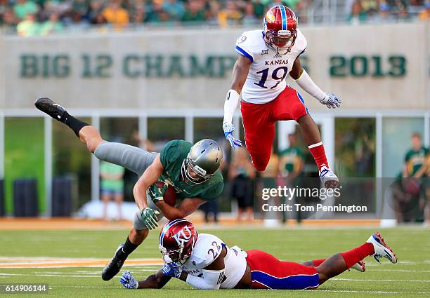 Blake Lynch of the Baylor Bears carries the ball against Isaiah Bean of the Kansas Jayhawks and Greg Allen of the Kansas Jayhawks in the fourth...