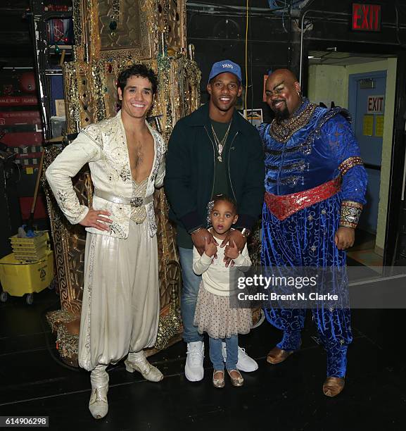 Professional football player Victor Cruz poses for photographs with Adam Jacobs , daughter Kennedy Cruz and James Monroe Iglehart after attending...