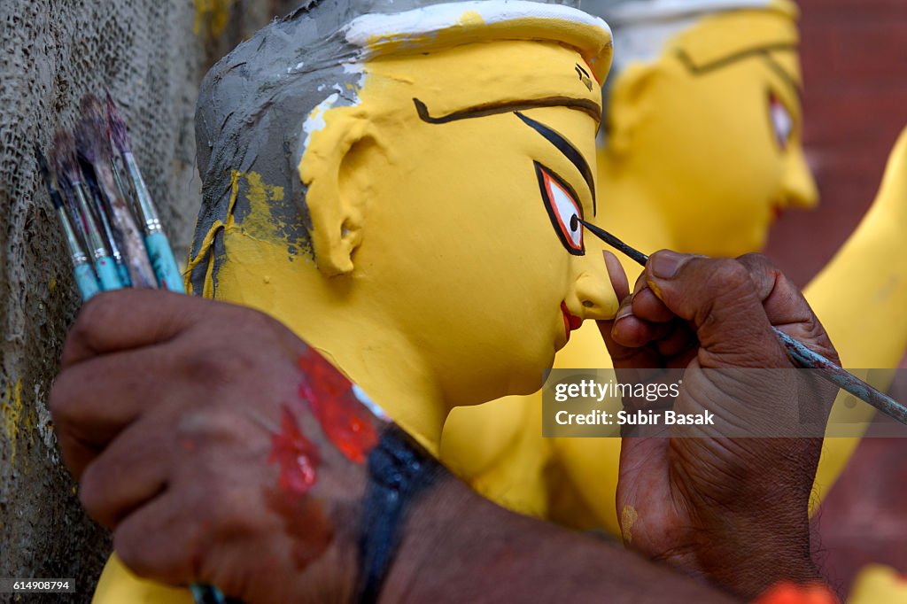 Painter painting on a statue of goddess Durga, Kolkata, West Bengal, India