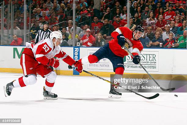 Reilly Smith of the Florida Panthers shoots the puck against Alexey Marchenko of the Detroit Red Wings at the BB&T Center on October 15, 2016 in...