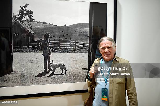 Photographer Henry Diltz poses with his photos in the Photography Experience during Desert Trip at the Empire Polo Field on October 15, 2016 in...