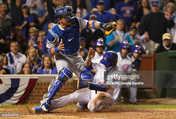 Javier Baez of the Chicago Cubs steals home in the second inning as Carlos Ruiz of the Los Angeles Dodgers is unable to make the tag during game one...