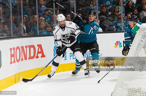 Teddy Purcell of the Los Angeles Kings skates with the puck against Tommy Wingels of the San Jose Sharks at SAP Center on October 12, 2016 in San...