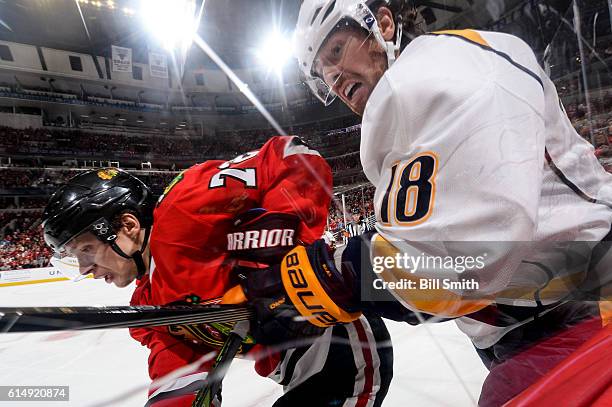 Artemi Panarin of the Chicago Blackhawks and James Neal of the Nashville Predators follow the puck around the boards in the second period at the...