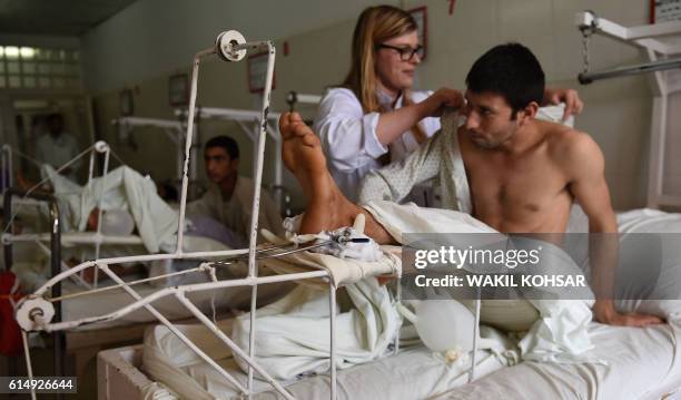 In this photograph taken on October 6 an Italian doctor assists a wounded Afghan National Army soldier after he received medical treatment at...