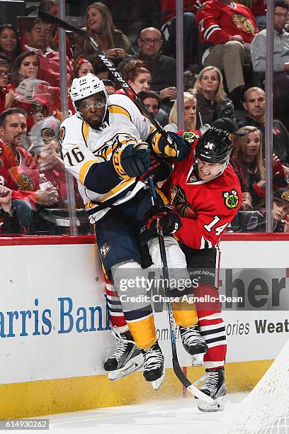 Richard Panik of the Chicago Blackhawks checks P.K. Subban of the Nashville Predators into the boards in the second period at the United Center on...