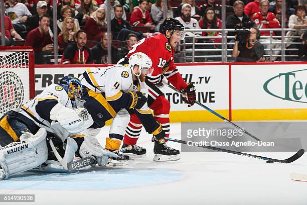 Jonathan Toews of the Chicago Blackhawks and Ryan Ellis of the Nashville Predators reach for the puck in front of goalie Marek Mazanec in the second...