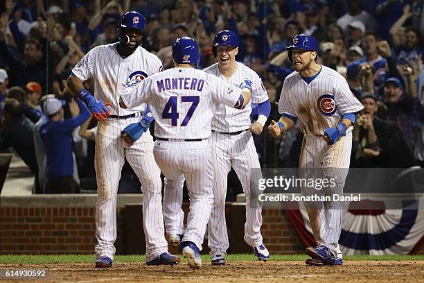 Miguel Montero of the Chicago Cubs celebrates with Jason Heyward, Chris Coghlan and Ben Zobrist after hitting a grand slam home run in the eighth...