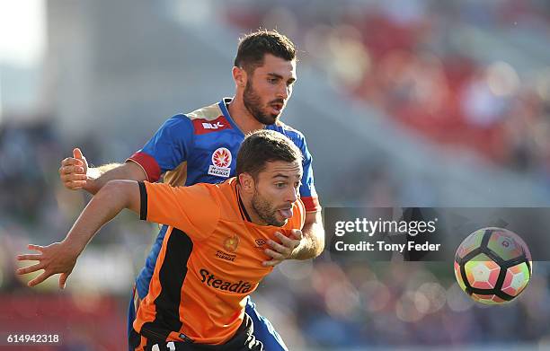 Nicholas Cowburn of the Jets contests the ball with Thomas Oar of the Roar during the round two A-League match between the Newcastle Jets and the...