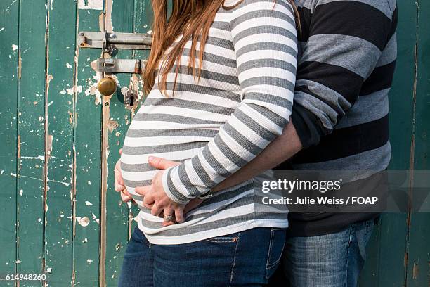 couple with hands on woman's belly - 2 5 maanden stockfoto's en -beelden