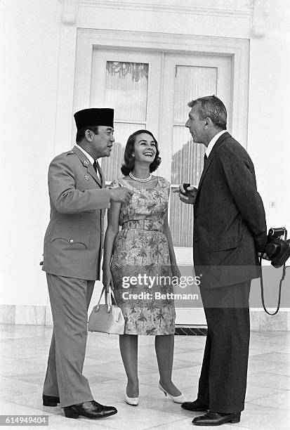 Film star Jean Simmons and her husband, writer-director Richard Brooks , listen attentively to Indonesia’s President Sukarno as he talks with them...