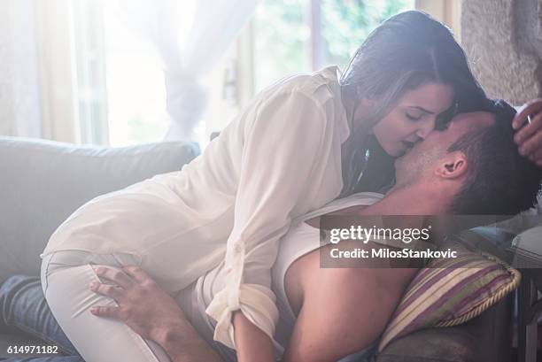 love passionate couple at sofa bed - man and woman kissing in bed stock pictures, royalty-free photos & images