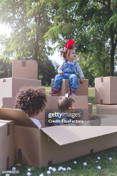 three multi ethnic babies playing outside in boxes - xmas eps stockfoto's en -beelden