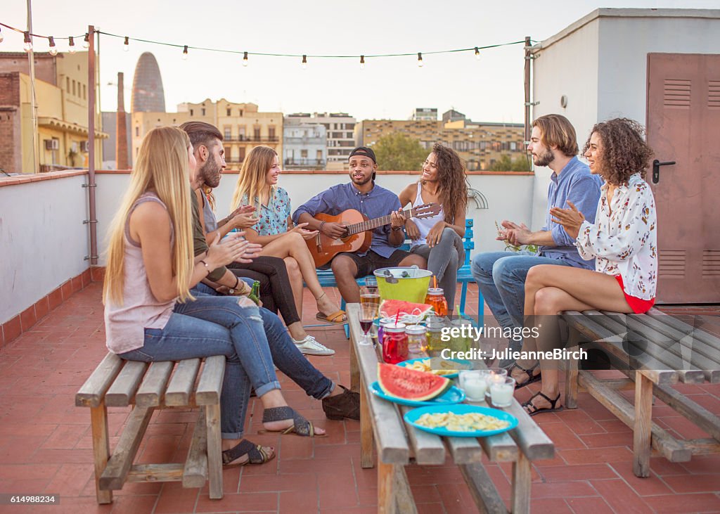 Friends playing guitar on rooftop