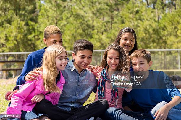 grupo de amigos pré-adolescentes tira 'selfie' com telefone inteligente. - season 14 - fotografias e filmes do acervo