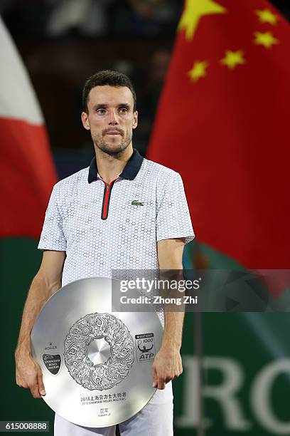 Roberto Bautista Agut of Spain reacts with his trophy during the award ceremony after losing the Men's singles final match against Andy Murray of...
