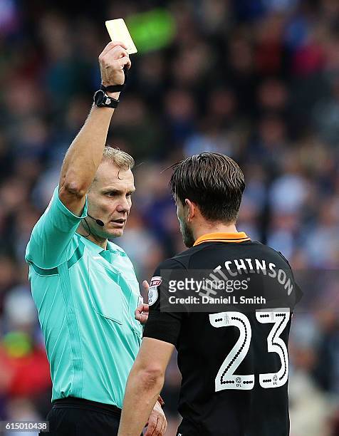 The referee issues Sam Hutchinson of Sheffield Wednesday a yellow card during the Sky Bet Championship match between Huddersfield Town and Sheffield...