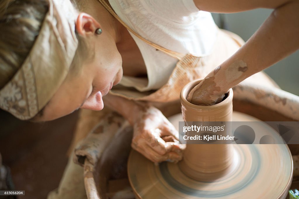 Woman makes hand made ceramics from clay III