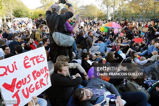 People sit during a "kiss-in" demonstration in defense of marriage equality, and against the Manif Pour Tous anti-same-sex marriage demonstration, at...