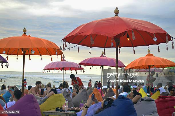 tourists lounging on bean bags by the beach in seminyak - bali stock pictures, royalty-free photos & images