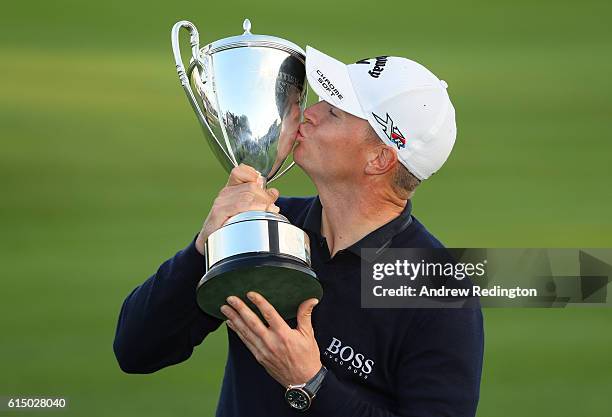 Alex Noren of Sweden kisses the trophy following his victory during the fourth round of the British Masters at The Grove on October 16, 2016 in...