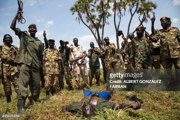 Graphic content / Soldiers of the Sudan People Liberation Army celebrate their victory over the body of a dead rebel soldier in Lelo, outside...