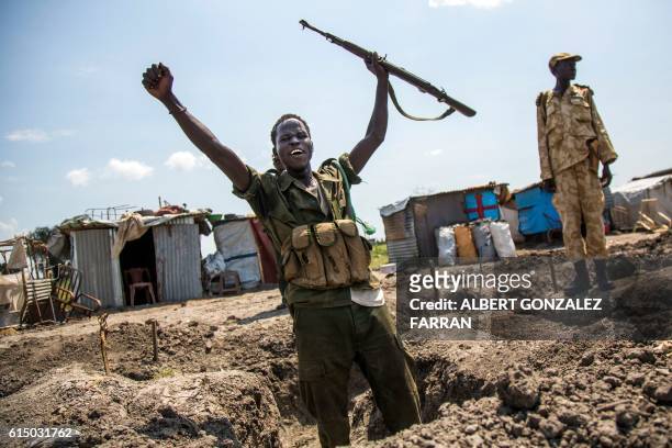 Soldiers of the Sudan People Liberation Army celebrates while standing in a trench in Lelo, outside Malakal, northern South Sudan, on October 16,...