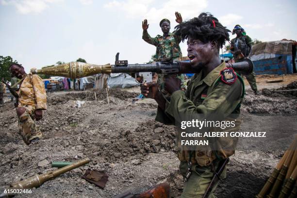 Soldiers of the Sudan People Liberation Army celebrate while standing in trenches in Lelo, outside Malakal, northern South Sudan, on October 16,...