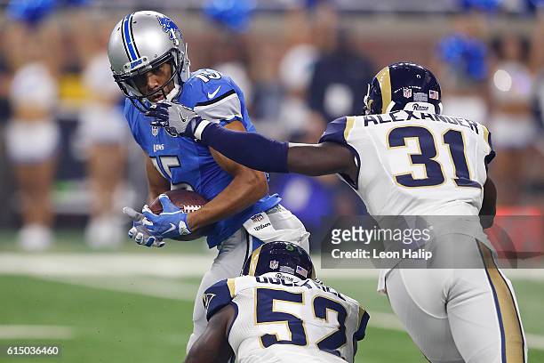 Golden Tate of the Detroit Lions runs the ball against Alec Ogletree of the Los Angeles Rams and Maurice Alexander during first quarter action at...
