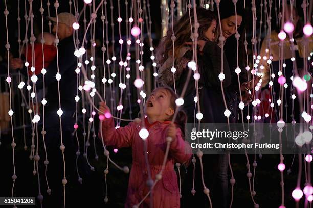 Young girl interacts with an LED lightshow as thousands of people gather on Leicester's Golden Mile to watch the switching on of the lights to mark...