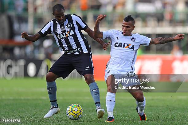 Airton of Botafogo struggles for the ball with Romulo Otero of Atletico Mineiro during a match between Botafogo and Atletico Mineiro as part of...
