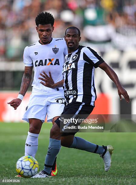 Airton of Botafogo struggles for the ball with Junior Urso of Atletico Mineiro during a match between Botafogo and Atletico Mineiro as part of...