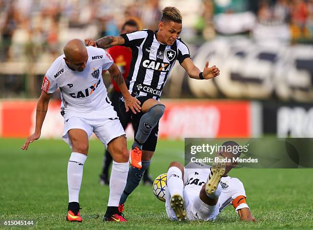 Neilton of Botafogo struggles for the ball with Fbio Santos and Leonardo Silva of Atletico Mineiro during a match between Botafogo and Atletico...