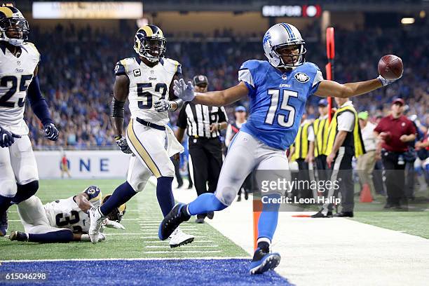Golden Tate of the Detroit Lions holds out the football after scoring a touchdown during fourth quarter action against the Los Angeles Rams at Ford...