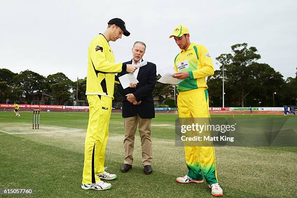 Warriors captain Adam Voges and Cricket Australia XI captain William Bosisto check the team sheets with match referee Bob Stratford before the...