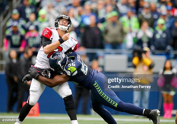 Quarterback Matt Ryan of the Atlanta Falcons is hit by defensive end Cliff Avril of the Seattle Seahawks at CenturyLink Field on October 16, 2016 in...