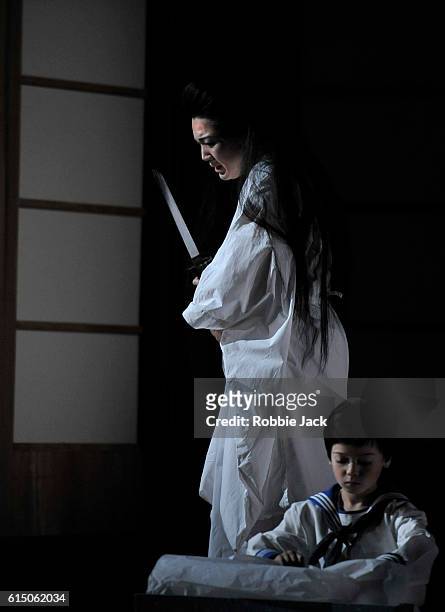 Karah Son as Cio-Cio-San and Rupert Wade as Sorrow in Giacomo Puccini's Madame Butterfly directed by Annilese Miskimmon designed by Nicky Shaw and...
