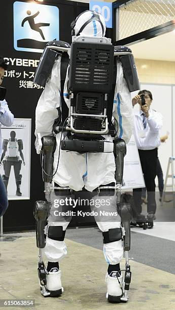 Japan - Photo shows a person wearing a new model of the HAL robotic suit at Tokyo Big Sight in Tokyo on Oct. 18 as the model is unveiled by maker...