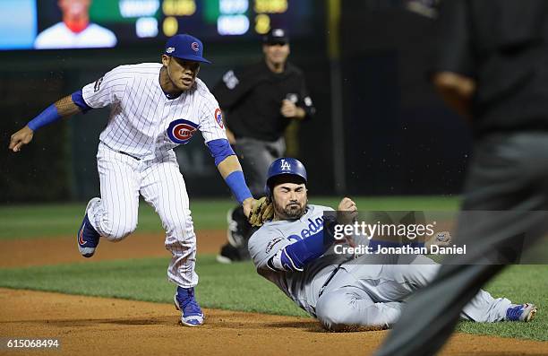 Addison Russell of the Chicago Cubs tags out Adrian Gonzalez of the Los Angeles Dodgers in the sixth inning to complete the double play during game...