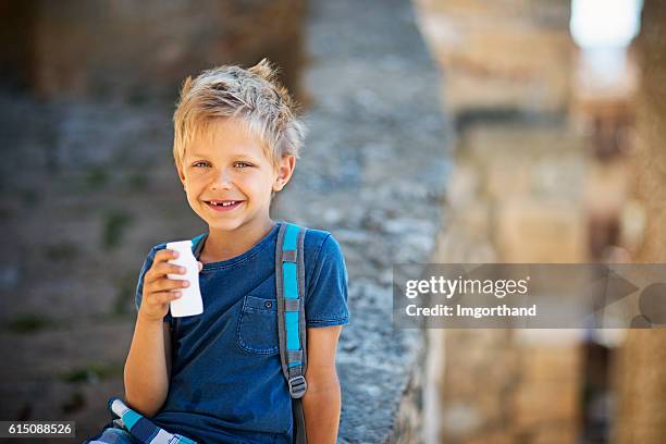 kleiner schuljunge, der joghurt trinkt - schulkind nur jungen stock-fotos und bilder