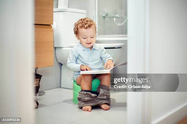 child sitting on the toilet - childrens closet stockfoto's en -beelden