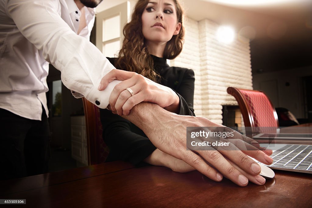 Harrassed woman removing his hand. She wears ring.