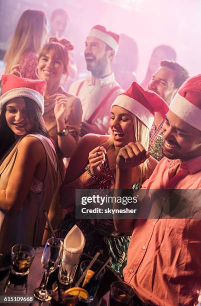 group of happy friends in club dancing on christmas party. - christmas party stockfoto's en -beelden